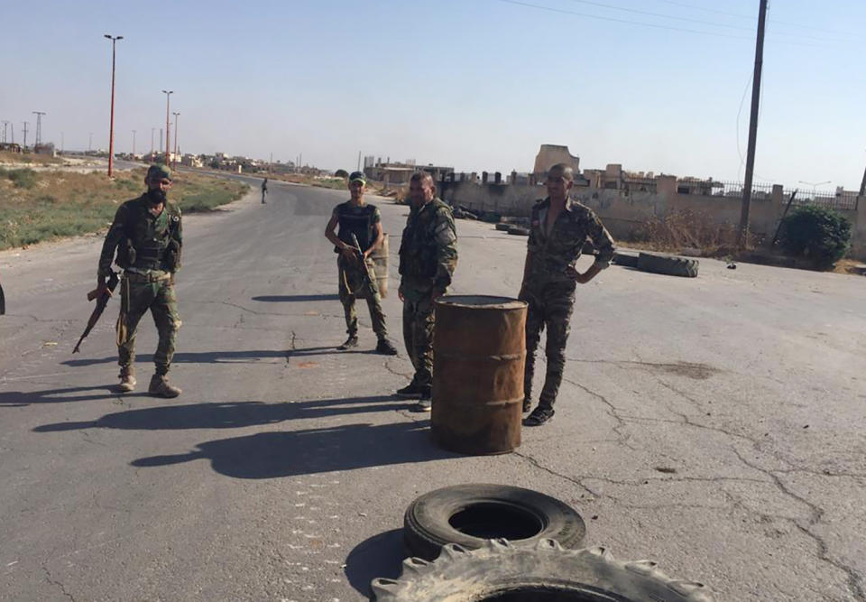 Four Syrian troops man a checkpoint at the entrance of the northwestern town of Khan Sheikhoun, Syria on Saturday, Aug. 24, 2019. (AP Photo/Albert Aji)