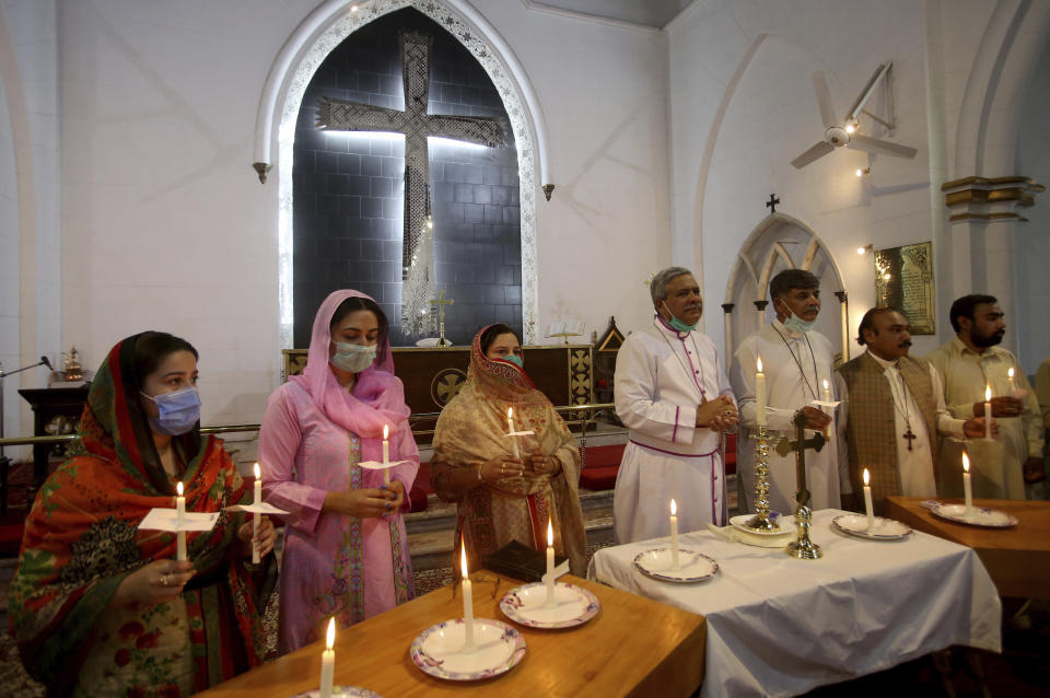 Christians hold candles during a prayer service for the victims of a plane crash, at St. Johan Cathedral in Peshawar, Pakistan, Saturday, May 23, 2020. A Pakistan International Airlines carrying passengers and crew has crashed near the southern port city of Karachi on Friday. (AP Photo/Muhammad Sajjad)