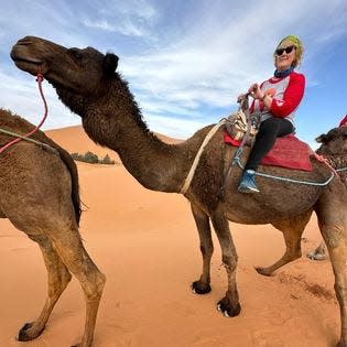 Reporter Patti Zarling riding a camel in the Sahara Desert, February 2024