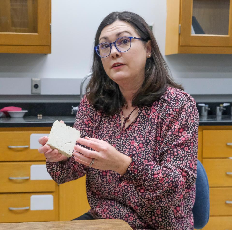 University of Alabama Professor Jennifer Feltman on Friday, Sept. 8, 2023 holds up a piece of limestone like that which was used to create the statues at Notre Dame Cathedral.