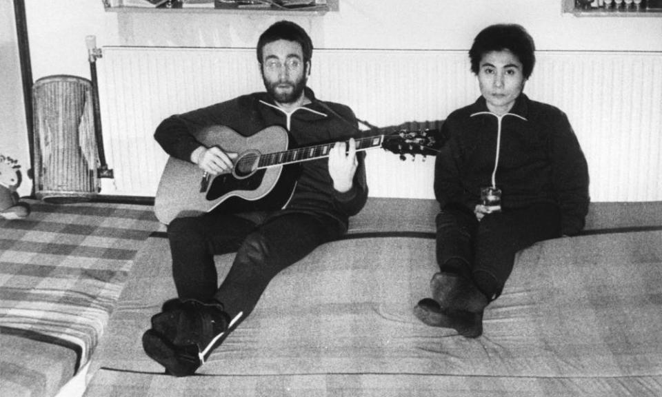 John Lennon, sitting next to his wife Yoko Ono, plays guitar in Herred during their visit to Jutland in Denmark.