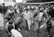 FILE — Fans attempt to take apart Yankee Stadium in New York City, on the last day of the season, Sept. 30,1973. It was the last day of the old stadium, in use since 1923. The 100th anniversary of the original Yankee Stadium is marked Tuesday, April 18, 2023, a ballpark that revolutionized baseball with its grandeur and the success of the team. (AP Photo/Richard Drew, File)