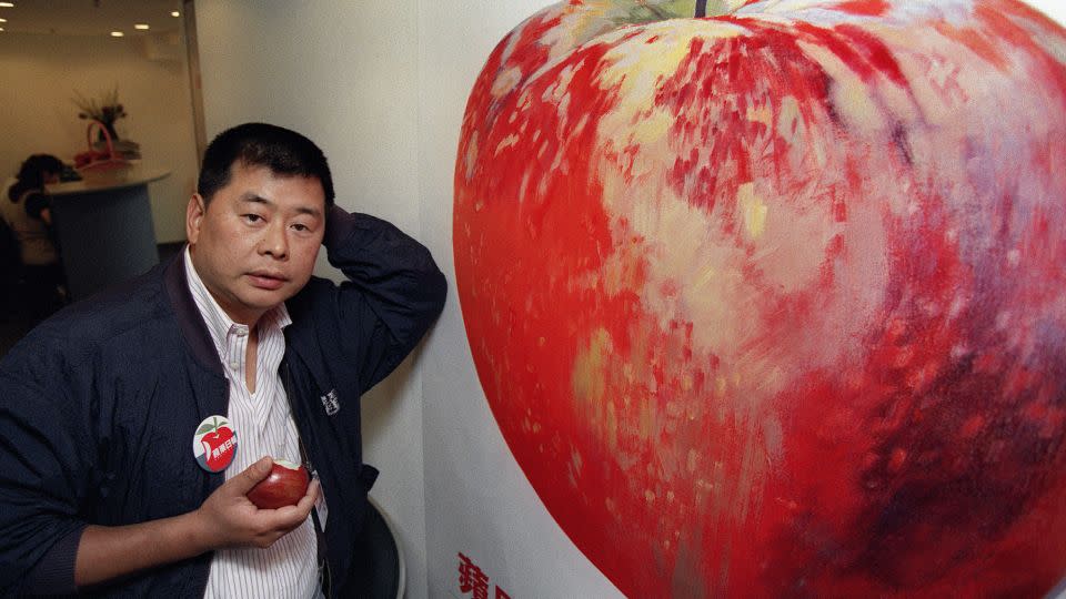 Hong Kong tycoon Jimmy Lai  in 1995 posing in front of a poster advertising his newly launched newspaper Apple Daily. - Mike Clarke/AFP/Getty Images