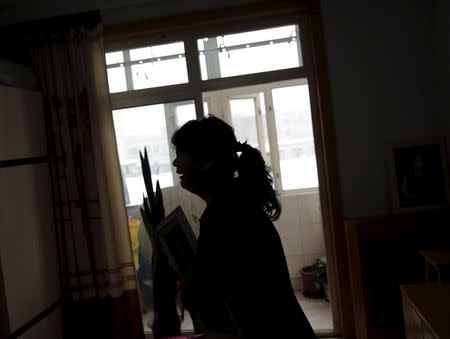 Huang Peiyao, 54, cries as she shows a picture of her dead son to reporters during an interview at her house in Zhangjiakou, China, November 22, 2015. REUTERS/Kim Kyung-Hoon