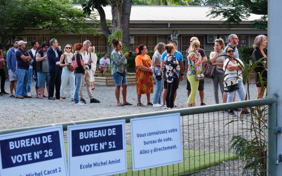 People queue outside a polling station in New Caledonia