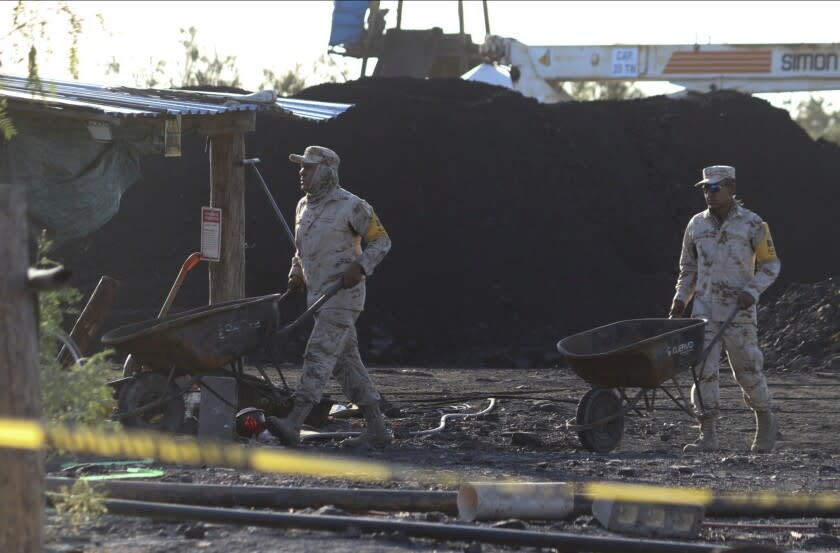 Soldados mexicanos mueven carretillas mientras ayudan en el rescate de 10 mineros atrapados en una mina de carbón colapsada e inundada en Sabinas, estado de Coahuila, México, el jueves 4 de agosto de 2022. (AP Foto/Alfredo Lara)