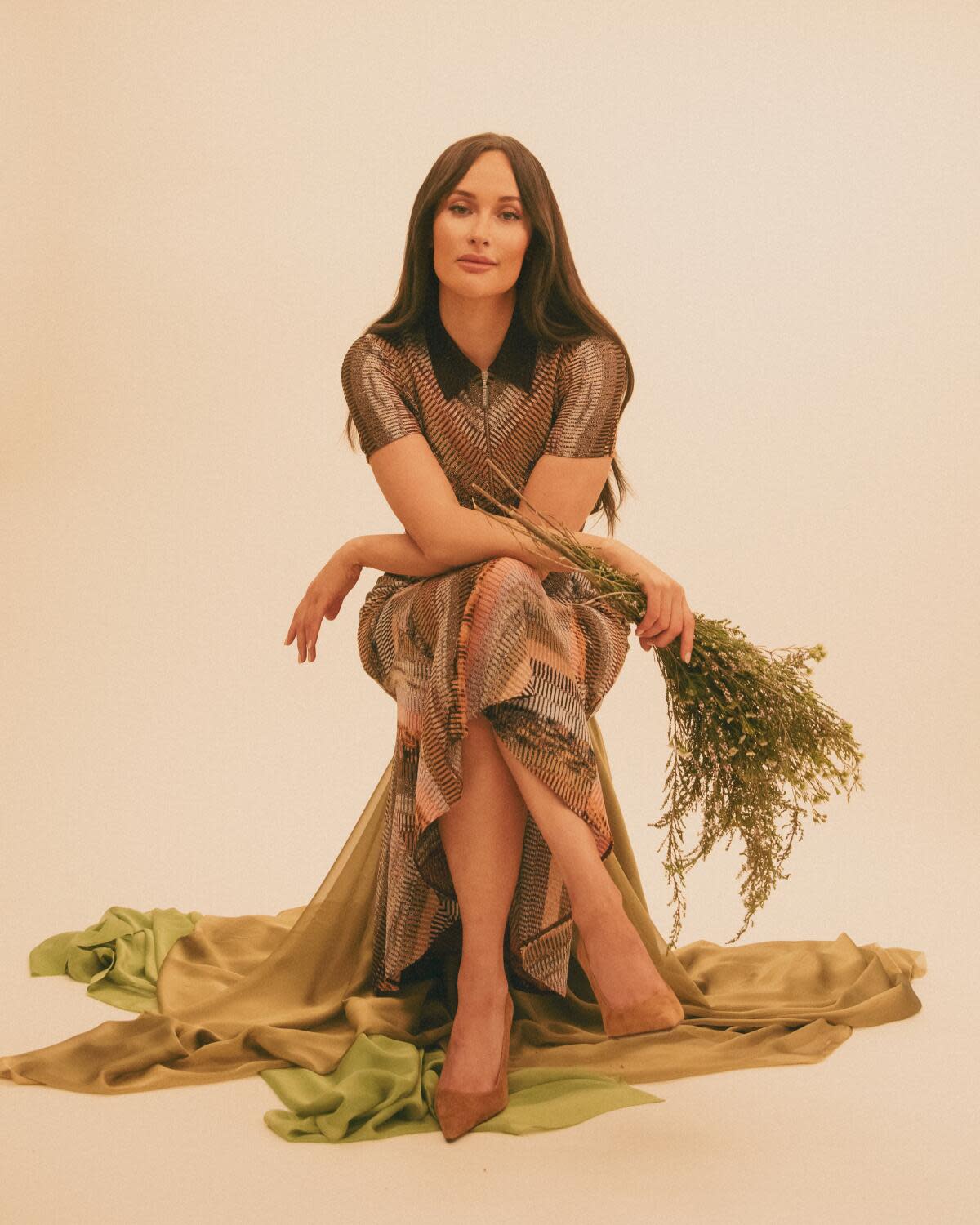 A woman seated holding some flowers.