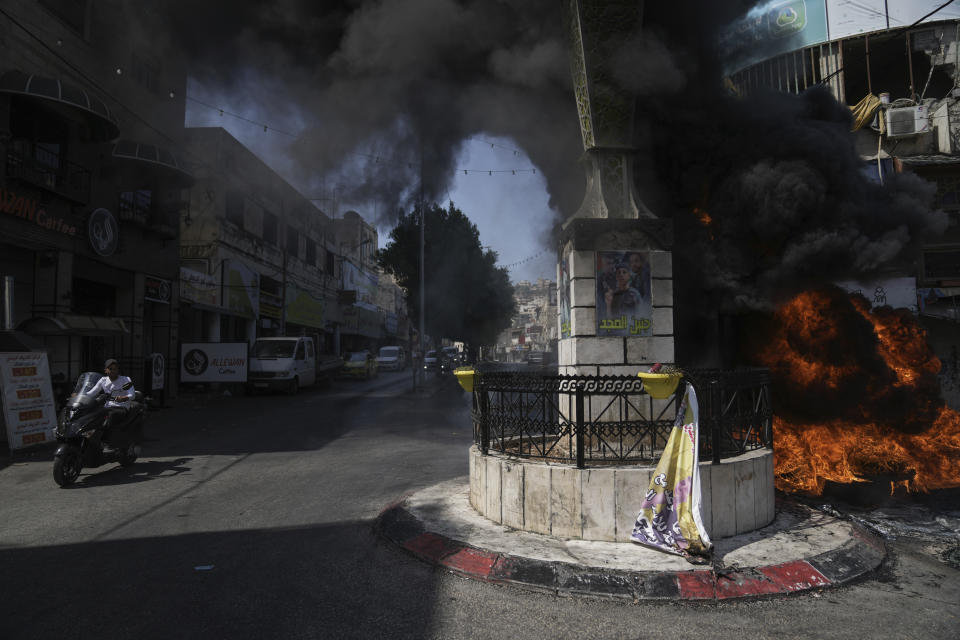 Tires burn during an Israeli military raid in the militant stronghold of Jenin refugee camp in the occupied West Bank, Monday, July 3, 2023. Israeli drones struck targets in the area early Monday and hundreds of troops were deployed. Palestinian health officials said at least five Palestinians were killed. (AP Photo/Nasser Nasser)