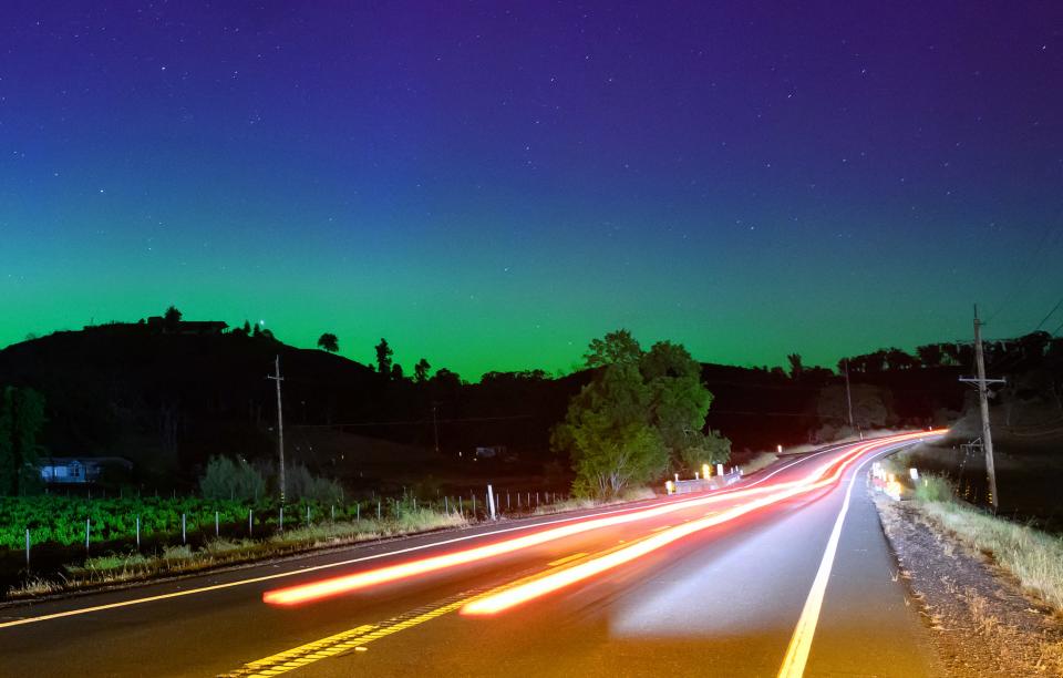 Northern lights or aurora borealis illuminate the night sky along a highway north of San Francisco in Middletown, California on May 11, 2024. The most powerful solar storm in more than two decades struck Earth, triggering spectacular celestial light shows from Tasmania to Britain -- and threatening possible disruptions to satellites and power grids as it persists into the weekend.