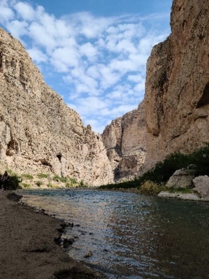 A still body of water lays below the dry Chisos Mountais of Big Bend.