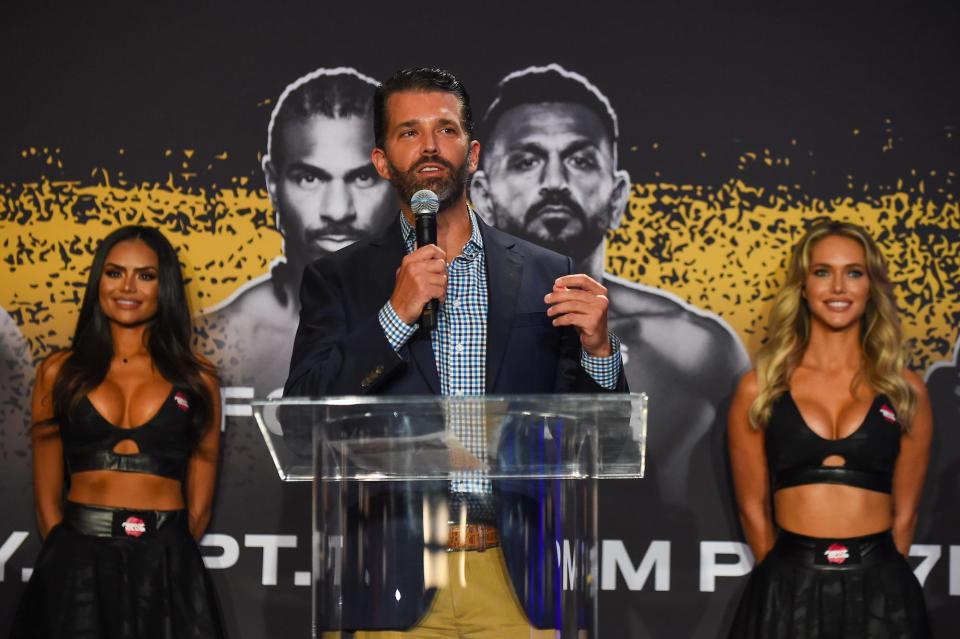 Donald Trump Jr., flanked by two ring girls, speaks during a press conference ahead of the heavyweight fight between Evander Holyfield and Vitor Belfort on September 11 at The Harbor Beach Marriott on September 9, 2021 in Fort Lauderdale, Florida.