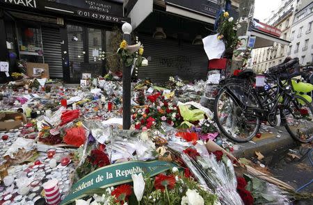 Candles, flowers and messages pay tribute to victims in front of the La Belle Equipe cafe, one of the sites of the deadly attacks in Paris, France, November 17, 2015. REUTERS/Jacky Naegelen