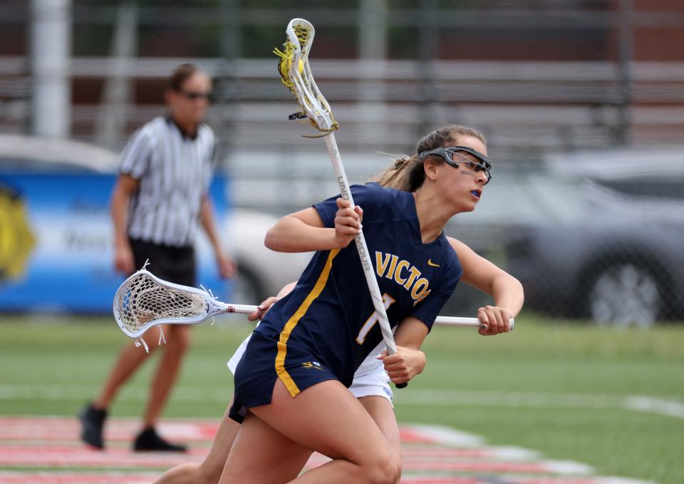 Victor's Eva Pronti carries the ball behind the net.