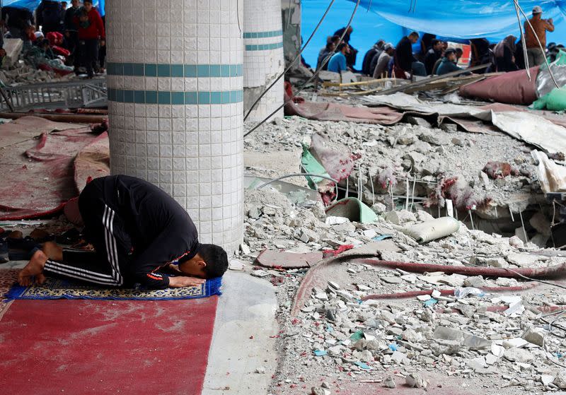 A Palestinian man performs Friday prayers at the ruins of a mosque destroyed in Israeli strikes, amid the ongoing conflict between Israel and Hamas, in Rafah in the southern Gaza Strip