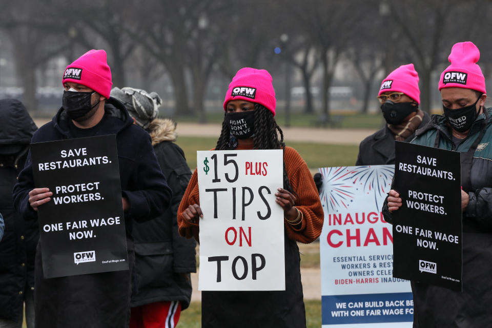 WASHINGTON, DC - JANUARY 26: Service industry workers listen to remarks and hold up signs during a rally in support of today's introduction of the Raise the Wage Act, which includes a $15 minimum wage for tipped workers and is also included in President Biden's American Rescue Plan at the National Mall on January 26, 2021 in Washington, DC. (Photo by Jemal Countess/Getty Images for One Fair Wage)