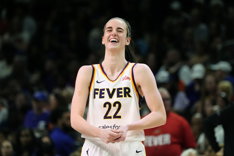 Indiana Fever guard Caitlin Clark laughs as she talks with Phoenix Mercury's Diana Taurasi prior to a WNBA basketball game, Sunday, June 30, 2024, in Phoenix. (AP Photo/Ross D. Franklin)