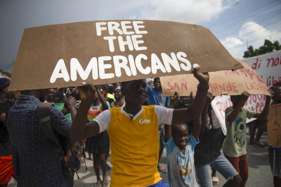 People protest for the release of kidnapped missionaries near the missionaries' headquarters in Titanyen, north of Port-au-Prince, Haiti, Tuesday, Oct. 19, 2021. A group of 17 U.S. missionaries including children was kidnapped by a gang in Haiti on Saturday, Oct. 16, according to a voice message sent to various religious missions by an organization with direct knowledge of the incident. (AP Photo/Joseph Odelyn)