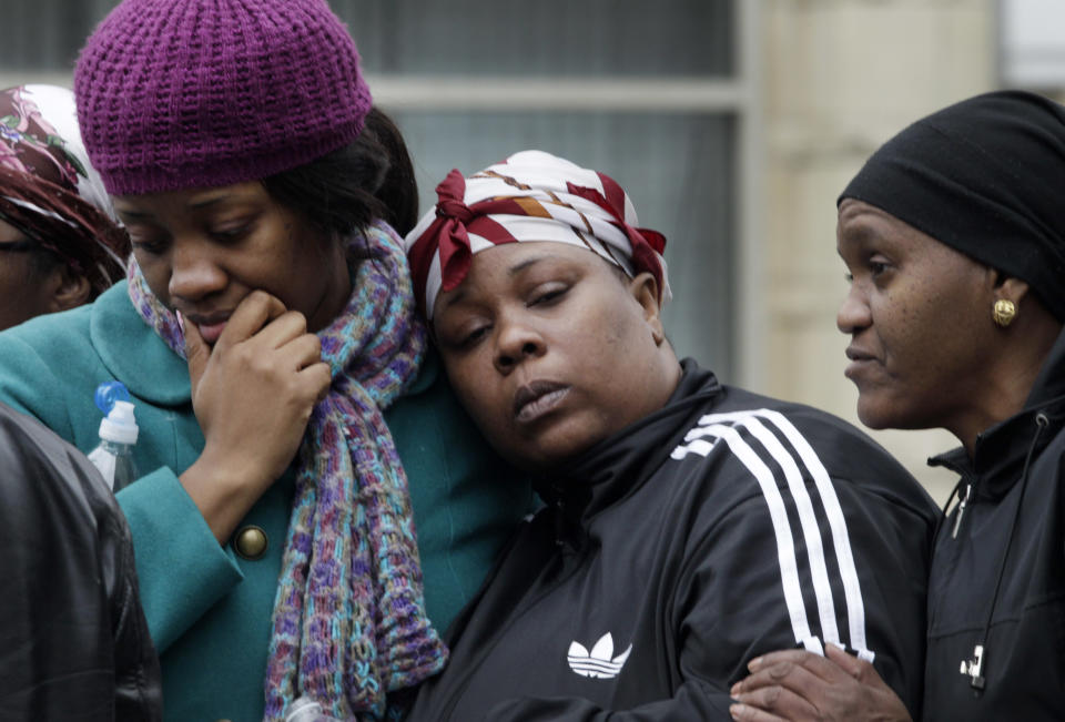 Alecia Thomas, left, is comforted by her friend Shivon Dollar, center, after she lost her home following an explosion that leveled two apartment buildings in the East Harlem neighborhood of New York, Wednesday, March 12, 2014. The blast happened after a neighbor reported smelling natural gas. The woman on the right is unidentified. (AP Photo/Mark Lennihan)