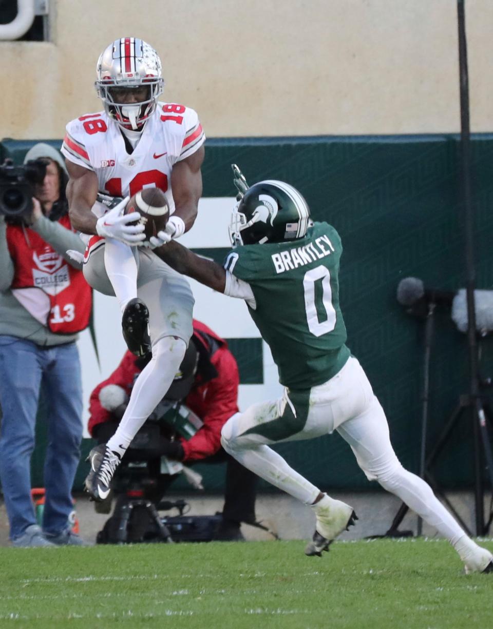 Ohio State Buckeyes wide receiver Marvin Harrison Jr. (18) catches a touchdown against Michigan State Spartans cornerback Charles Brantley (0) during second half action at Spartan Stadium Saturday, October 8, 2022.