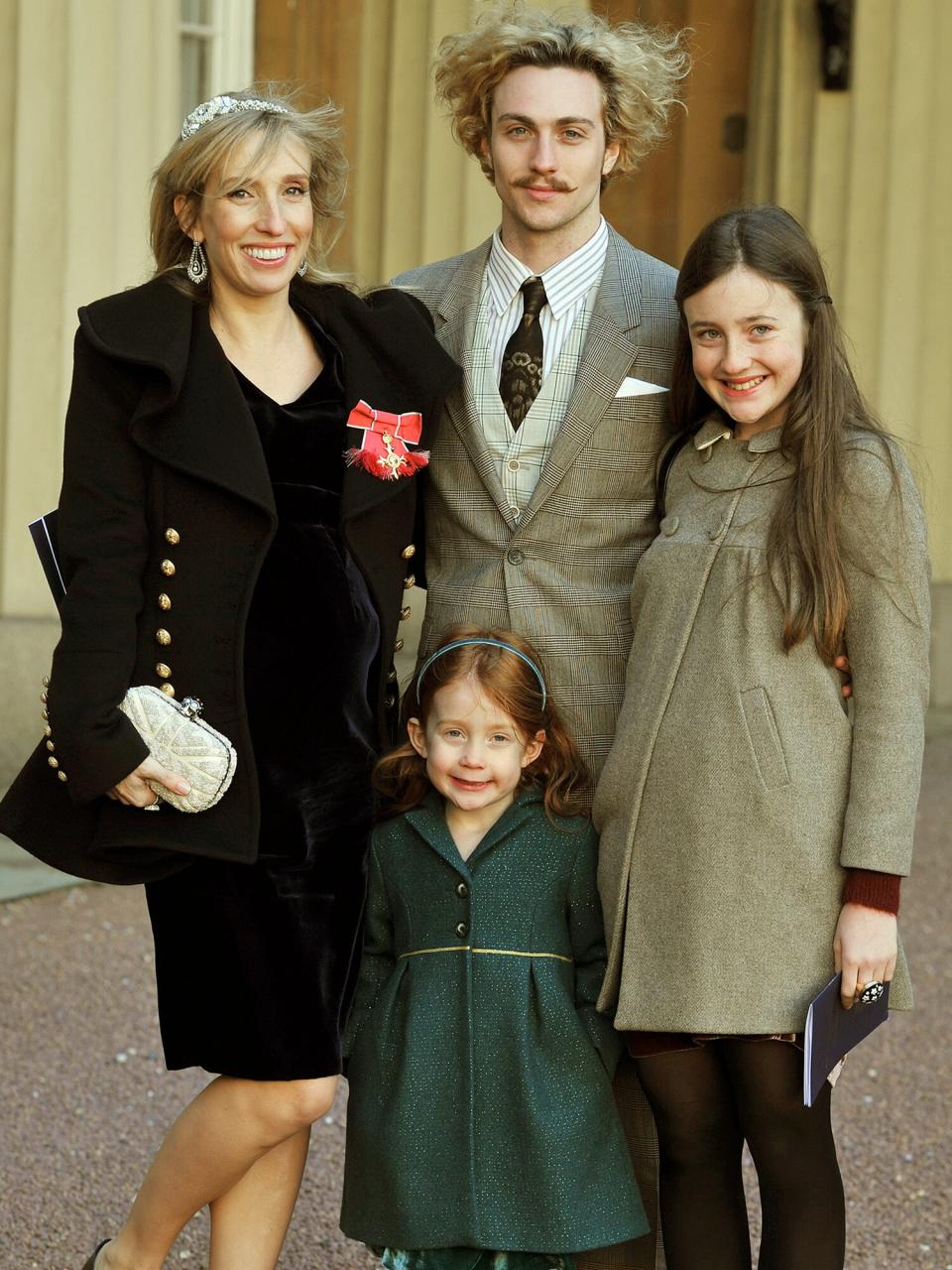 Sam Taylor-Wood wears her OBE with partner Aaron Johnson and her children Angelica (R) and Jessie after it was presented to her by Prince Charles, Prince of Wales during an Investiture Ceremony at Buckingham Palace on December 14, 2011 in London