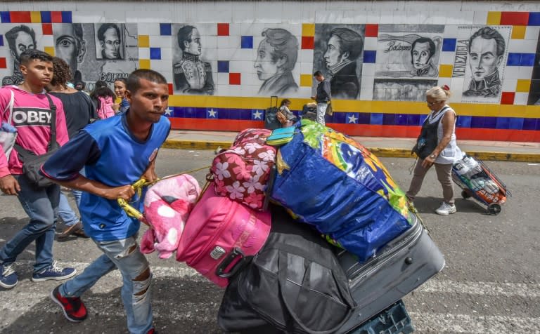 Thousands of Venezuelans, many hauling overloaded suitcases, cross the border into Colombia to escape unrest and penury at home