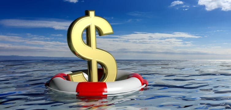 Lifebuoy and a golden dollar symbol on blue sea and sky background.