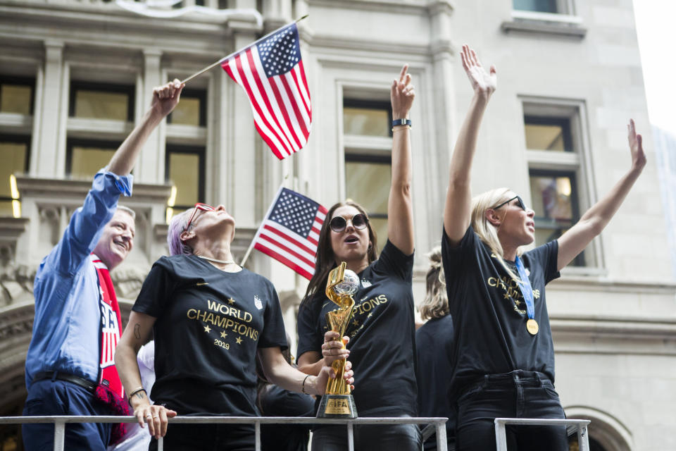 Alex Morgan, center, holds the World Cup trophy with teammate Megan Rapinoe at the parade. (Photo: Ira L. Black - Corbis via Getty Images)