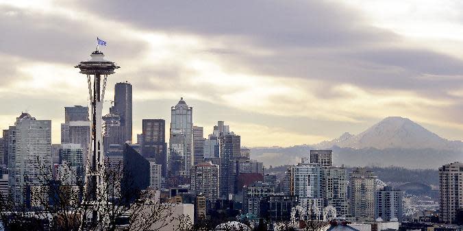 The Seattle Seahawks "12" flag flutters atop the Space Needle and in view of downtown Seattle and Mount Rainier beyond after being raised minutes earlier atop the iconic structure, Friday, Jan. 13, 2017. The flag was raised in support of the Seahawks' NFC Divisional playoff game Saturday against the Atlanta Falcons. (AP Photo/Elaine Thompson)