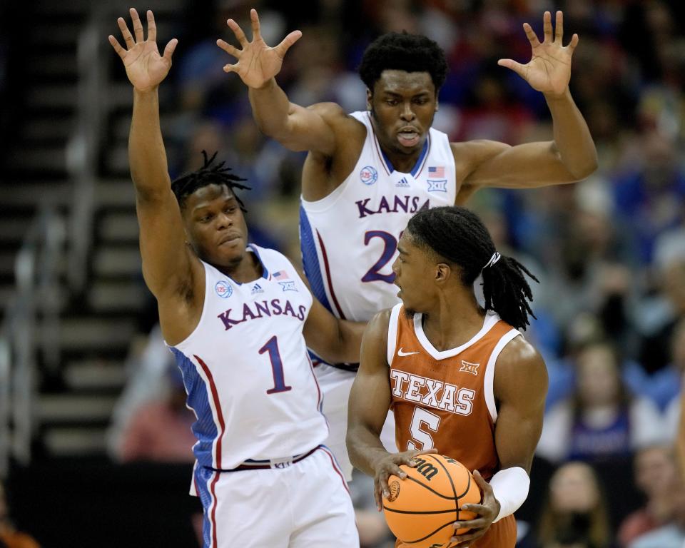 Texas' Marcus Carr (5) tries to pass as Kansas' Joseph Yesufu and Ernest Udeh Jr. defend during the Big 12 Championship Game on Saturday.