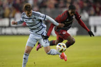 Toronto FC forward Prince Osei Owusu (99) and Sporting Kansas City midfielder Jake Davis (17) battle for the ball during the first half of an MLS soccer game in Toronto, Ontario, Saturday, March 30, 2024. (Frank Gunn/The Canadian Press via AP)