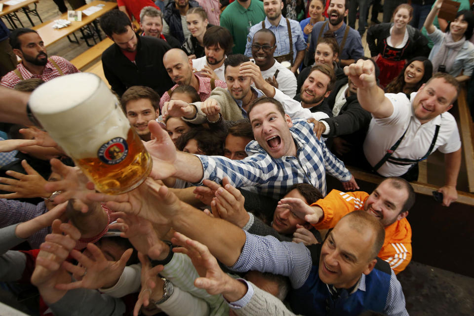 Visitors reach for the one of the first mugs of beer during the opening day of the 183rd Oktoberfest in Munich