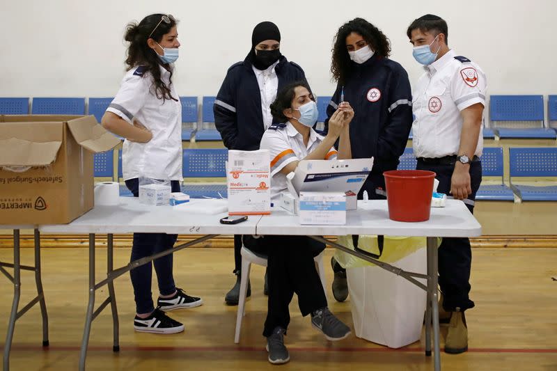 Medical personnel work at a temporary vaccination centre where vaccinations against the coronavirus disease (COVID-19) are administered, at a sports court in Tel Aviv