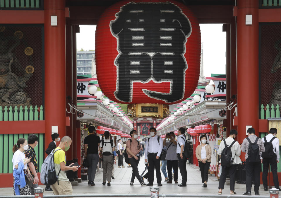 People wearing face masks to help protect against the spread of the coronavirus walk along the Asakusa area in Tokyo, Wednesday, June 30, 2021. (AP Photo/Koji Sasahara)