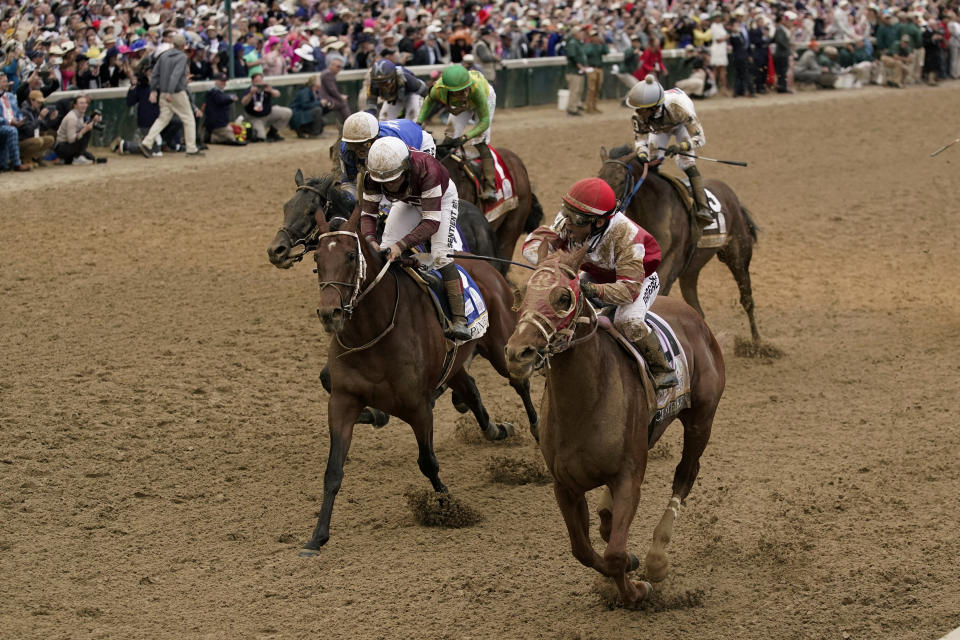 Rich Strike, right, with Sonny Leon aboard, crosses the finish line to win the 148th running of the Kentucky Derby horse race at Churchill Downs Saturday, May 7, 2022, in Louisville, Ky. (AP Photo/Jeff Roberson)