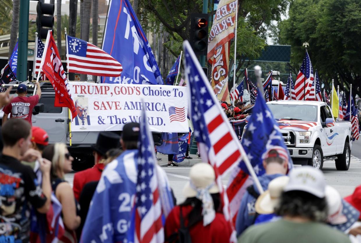 People waving flags and banners outside a convention center.