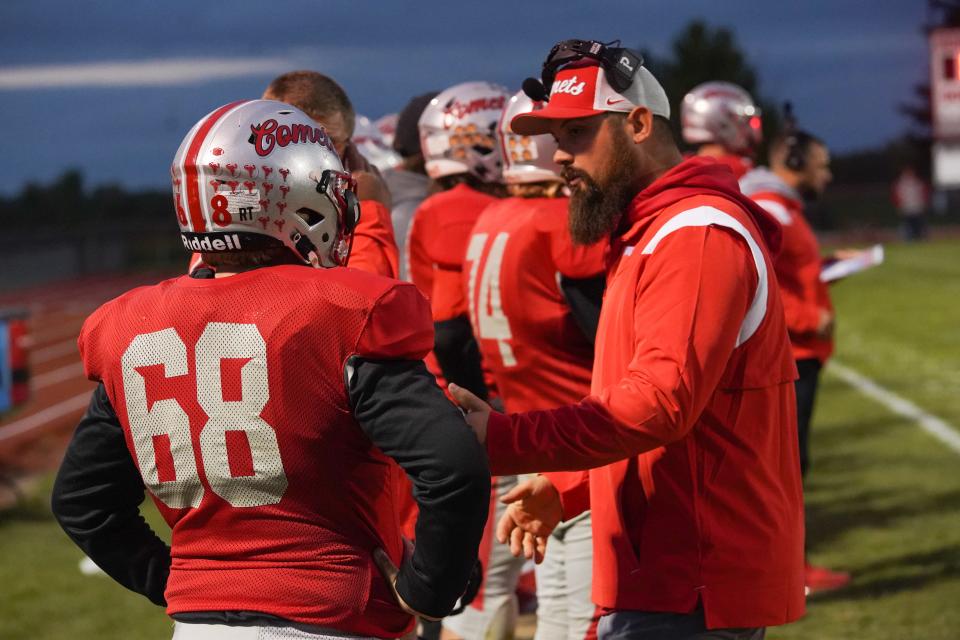 Elgin football coach Zack Winslow talks to Jacob Brown on the sideline of their football game against Ridgemont earlier this season. The Comets are in the playoffs for sixth time in school history.