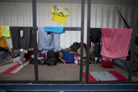 En esta imagen, tomada el 7 de septiembre de 2018, venezolanos descansan mientras esperan en un contenedor de mercancías cerca de la oficina de inmigración en Aguas Verdes, Peru. Venezolanos que no tienen dinero ni para autobuses se van a otros países a pie en busca de una nueva vida. (AP Foto/Ariana Cubillos)