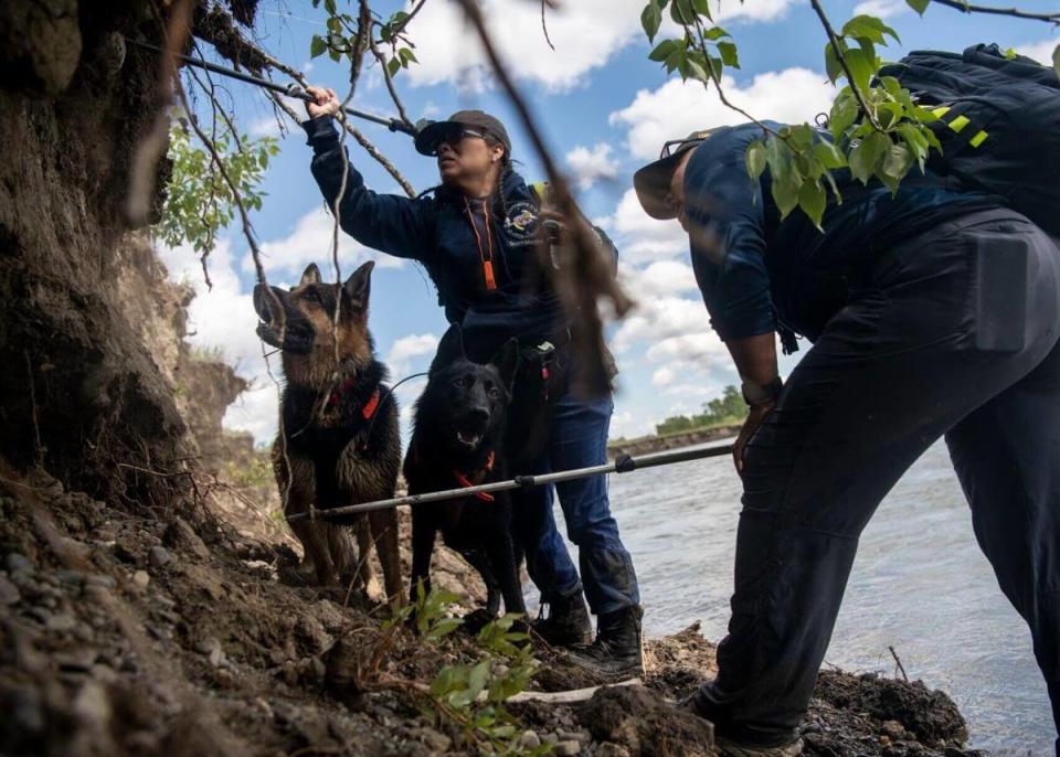 Andrea Beyal, left, and Bernadine Beyale of 4 Corners K-9 Search and Rescue are joined by dogs Trigger and Gunny in searching for a missing girl along the Two Medicine River near Browning, Mont., in July 2022.