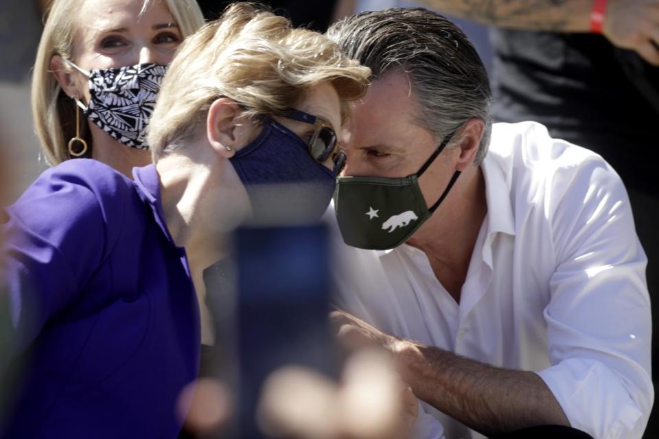 Gavin Newsom speaks to U.S. Senator Elizabeth Warren during the rally.