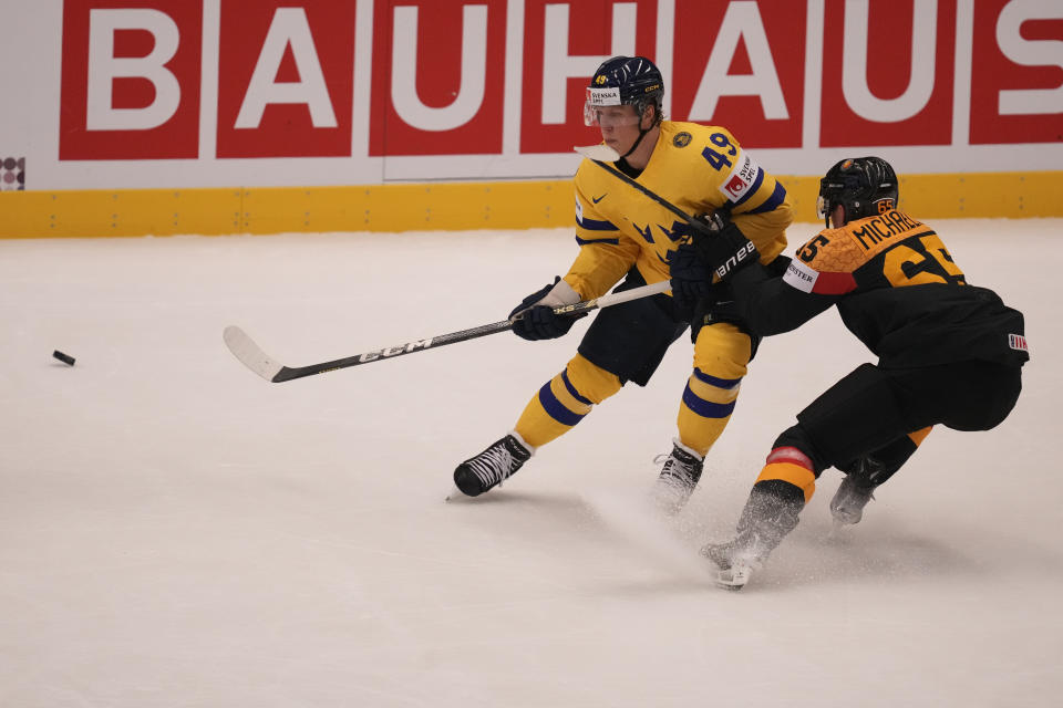 Sweden's Fabian Zetterlund, left, challenges for a puck with Germany's Marc Michaelis during the preliminary round match between Germany and Sweden at the Ice Hockey World Championships in Ostrava, Czech Republic, Monday, May 13, 2024. (AP Photo/Darko Vojinovic)