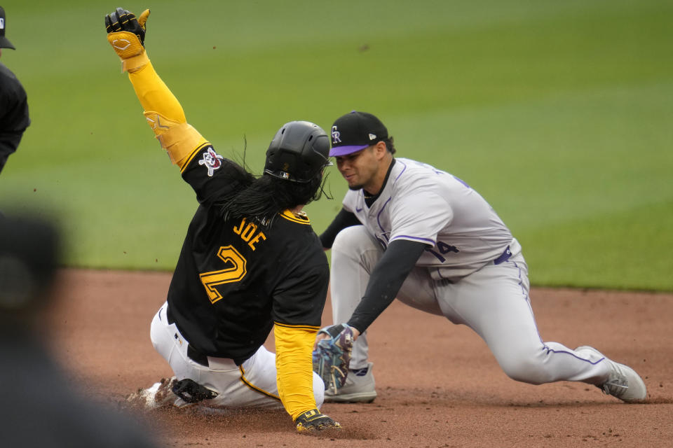 Colorado Rockies shortstop Ezequiel Tovar, right, tags out Pittsburgh Pirates' Connor Joe (2) who was attempting to stretch a single into a double during the first inning of a baseball game in Pittsburgh, Saturday, May 4, 2024. (AP Photo/Gene J. Puskar)