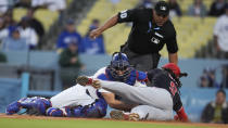 Los Angeles Dodgers catcher Austin Barnes, left, tags out Washington Nationals' CJ Abrams at home plate after a double by Jesse Winker during the first inning of a baseball game Tuesday, April 16, 2024, in Los Angeles. (AP Photo/Marcio Jose Sanchez)