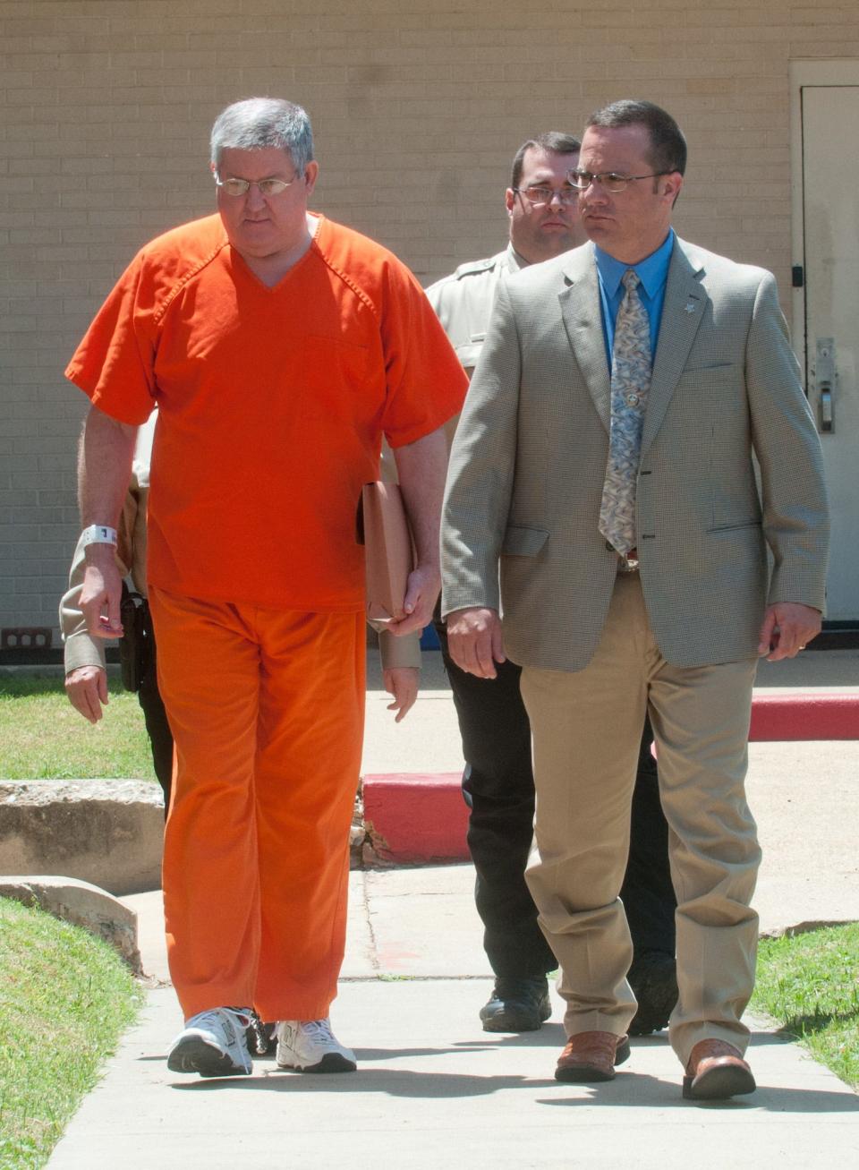 Bernie Tiede, left, is escorted by Panola County Sheriff Kevin Lake, right, and other deputies Tuesday, May 6, 2014, on his way to his hearing at the Panola County Courthouse in Carthage.