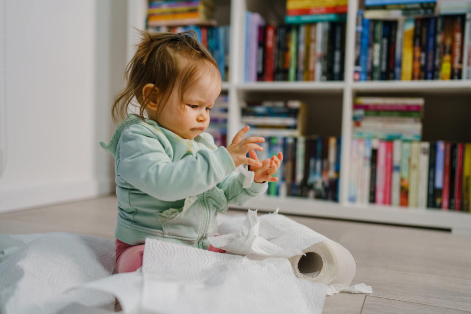 A child is ripping up paper towels