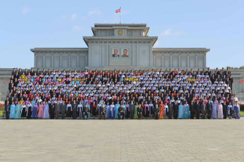 North Korean leader Kim Jong Un takes a photo with supporters  - Credit: Reuters