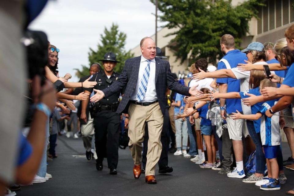 Kentucky head coach Mark Stoops high-fives fans during the Cat Walk before his team’s game against Northern Illinois on Saturday.