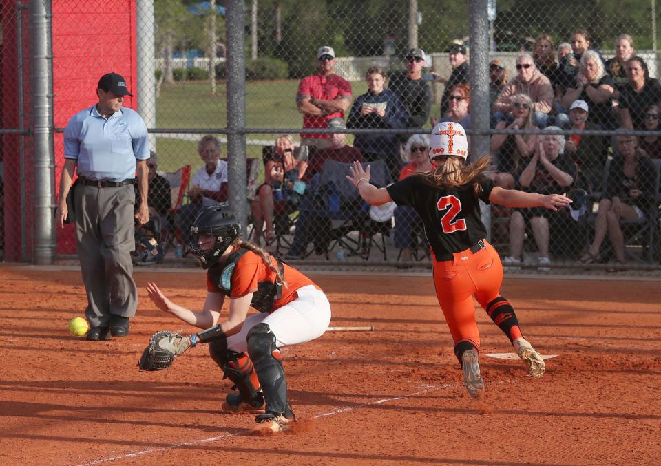 Spruce Creek High's Charlie Ring (2) scores as University High catcher Addison Pertler (11) waits on the throw, Thursday, April 18, 2024 during the Five Star Conference softball championship game at the Ormond Beach Sports Complex.