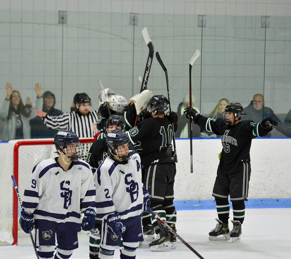 The Dartmouth boys ice hockey team celebrates after beating unbeaten Somerset Berkley. Raiders Noah Taylor (9) and Luke Gauvin skate off the ice.