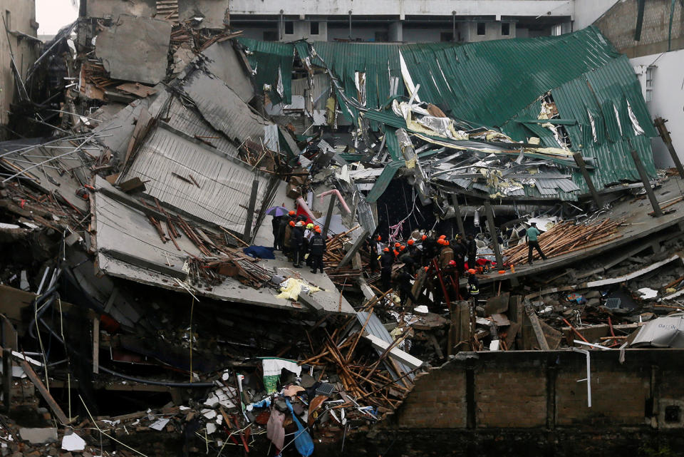 <p>Military officials and fire brigade members work during a rescue mission after a building collapsed in Colombo, Sri Lanka May 18, 2017. (Photo: Dinuka Liyanawatte/Reuters) </p>