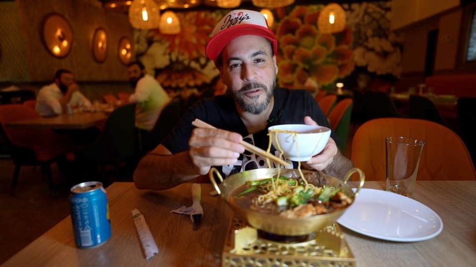 CW Silverberg, the host of ‘Schmoozing and Cruising,’ tries food at Bambu Pan Asian Kitchen, a kosher restaurant in North Miami Beach. Courtesy of ChaiFlicks